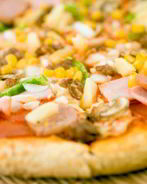 Пицца с ананасами, колбасой, сладкой кукурузой и томатами